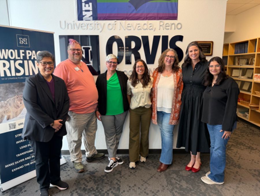 Team of seven streetreach members standing in front of the UNR Orvis sign